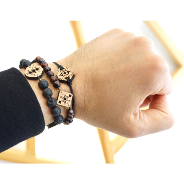 main portant 3 bracelets berbères en bois