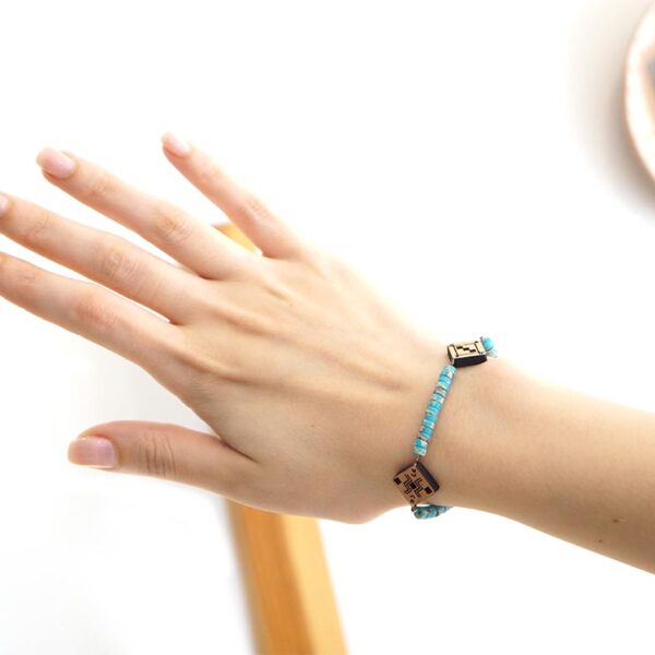 main qui porte un bracelet berbère en bois et en pierre naturelle