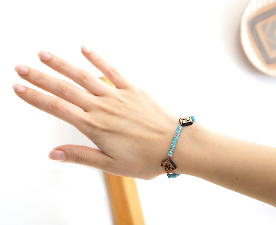 main qui porte un bracelet berbère en bois et en pierre naturelle